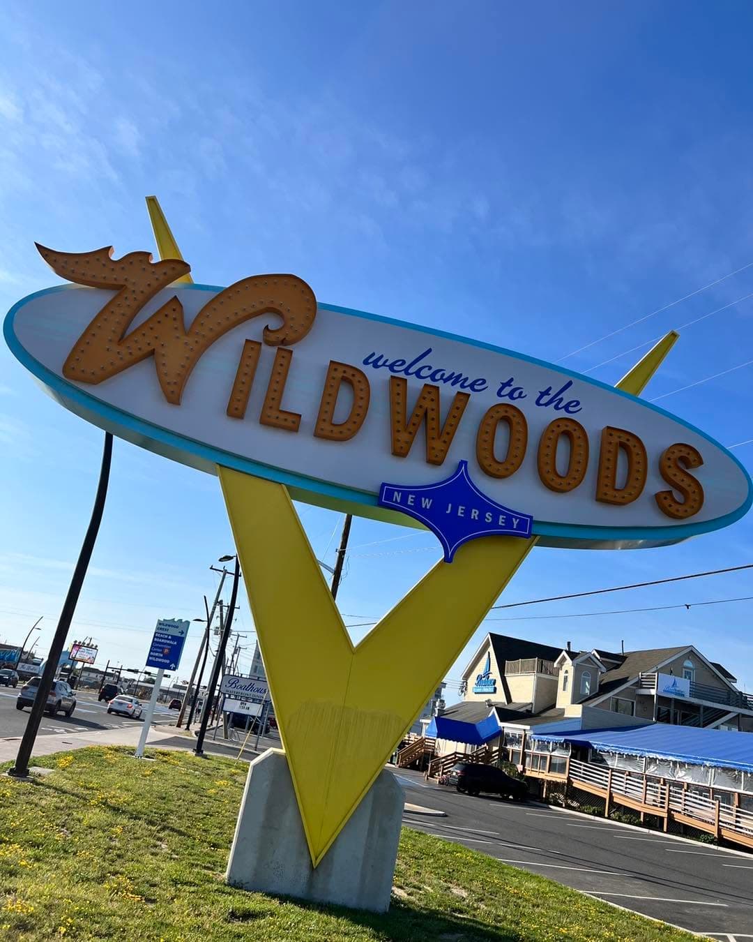 A colorful welcome sign for Wildwoods, New Jersey, against a clear blue sky.